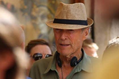 Clint Eastwood durante la lavorazione di un film con cappello e cuffie intorno al collo