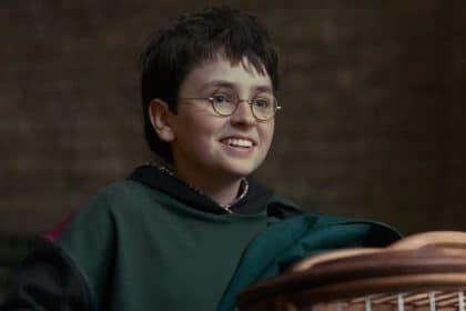 Dominic McLaughlin nei panni di Harry Potter davanti al castello di Hogwarts nella serie HBO